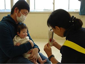 ボランティアが赤ちゃんに読み聞かせをしている写真